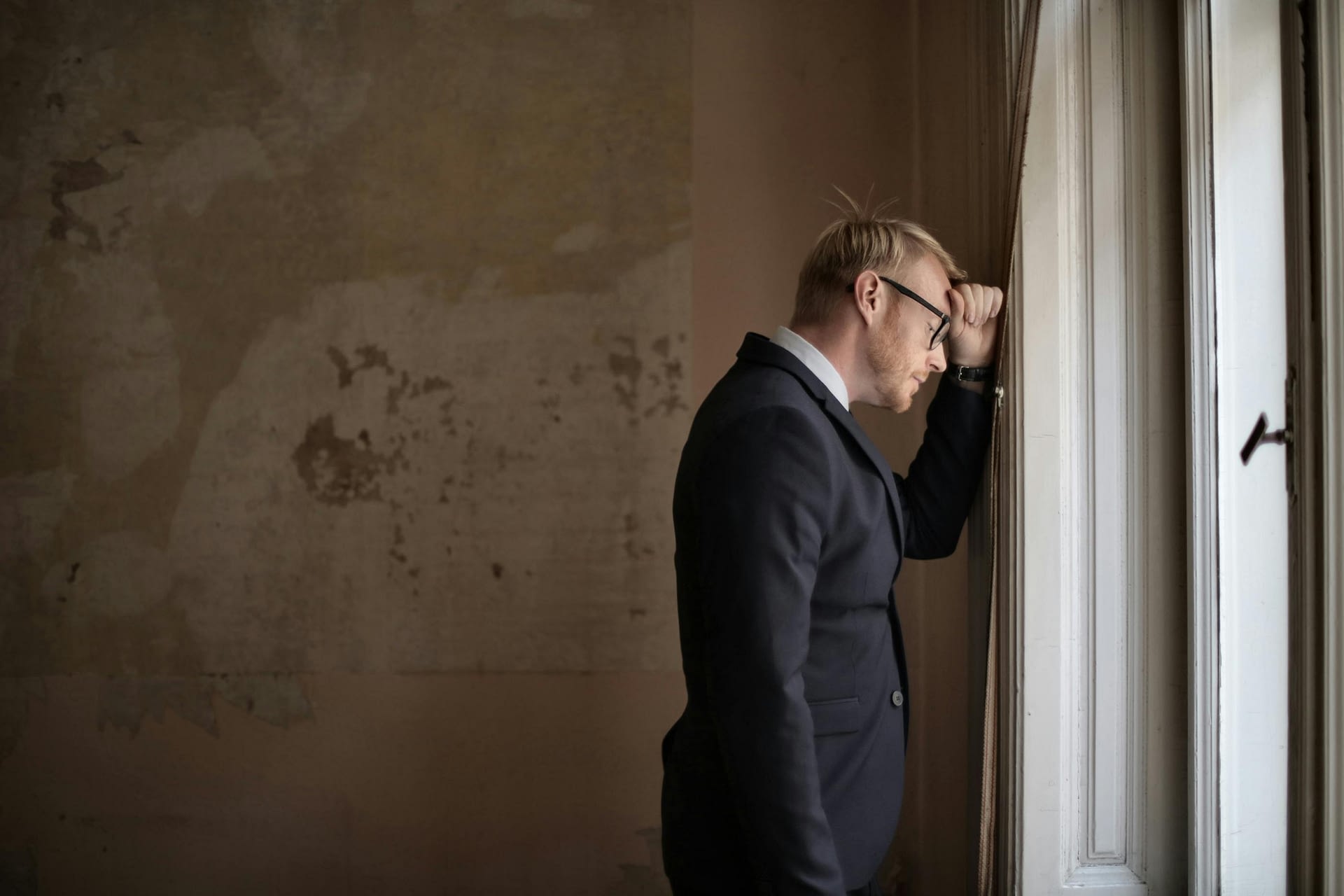 giving tough feedback -- male entrepreneur standing near window